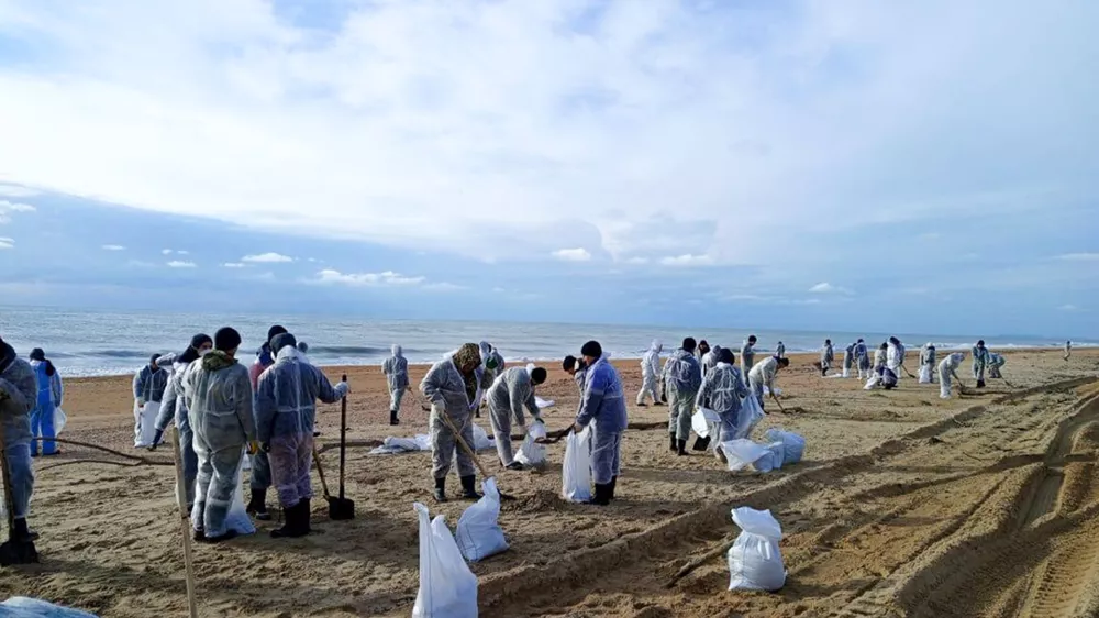 In this photo released by Krasnodar Gov. Veniamin Kondratyev in his Telegram channel on Sunday, Jan. 5, 2025, rescuers and volunteers work to clean up tons of fuel oil that spilled out of two storm-stricken tankers more than two weeks ago in the Kerch Strait, near Anapa in Russia's southern Krasnodar region. (Krasnodar Gov. Veniamin Kondratyev Telegram channel via AP)