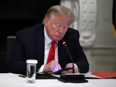 FILE - In this Thursday, June 18, 2020 file photo, President Donald Trump looks at his phone during a roundtable with governors on the reopening of America's small businesses, in the State Dining Room of the White House in Washington. On Wednesday, Jan. 25, 2023, Facebook parent Meta said in a blog post it is reinstating former President Trump's personal account after two-year suspension following the Jan. 6 insurrection. (AP Photo/Alex Brandon, File)