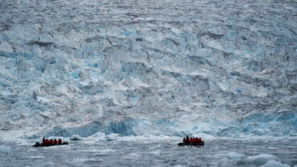 FILE - Two groups from the Poseidon Expeditions tour company look at a glacier in the Scoresby Sund, on Sept. 7, 2023, in Greenland. (AP Photo/Chris Szagola, File)