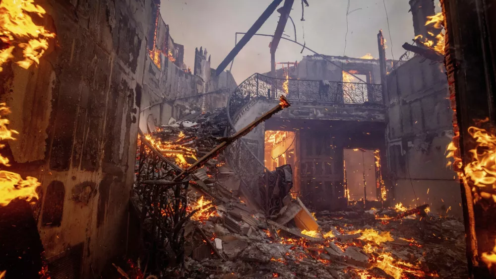 The Palisades Fire burns a residence in the Pacific Palisades neighborhood of Los Angeles, Tuesday, Jan. 7, 2025. (AP Photo/Ethan Swope)