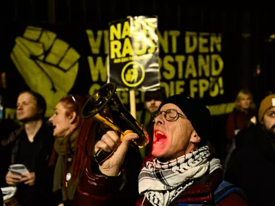 A man uses megaphone as he shouts during a protest against the mandate for Austria's far-right Freedom Party to lead a new government in Vienna, Austria, Thursday, Jan. 9, 2025. (AP Photo/Denes Erdos)