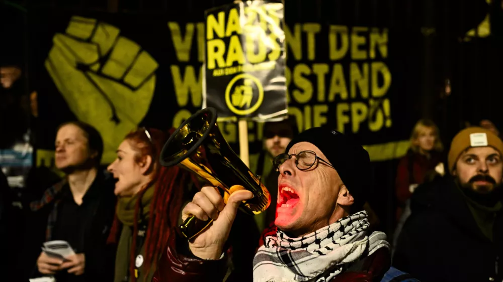 A man uses megaphone as he shouts during a protest against the mandate for Austria's far-right Freedom Party to lead a new government in Vienna, Austria, Thursday, Jan. 9, 2025. (AP Photo/Denes Erdos)