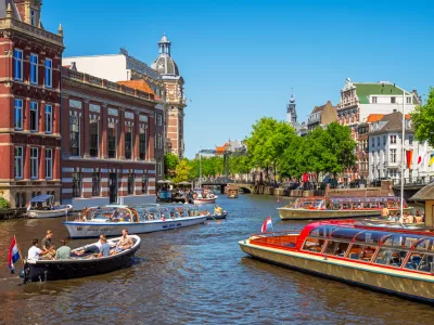 Amsterdam, Netherlands - June 3, 2023: Canal in Amsterdam, Netherlands busy with boat traffic on sunny saturday afternoon in June.