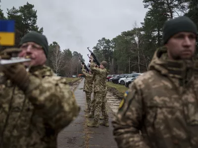 Honour Guard fire into the air during the funeral ceremony of Ukrainian serviceman Andriy Kuzmenko in a cemetery in Kyiv, Ukraine, Friday Jan. 10, 2025. (AP Photo/Evgeniy Maloletka)