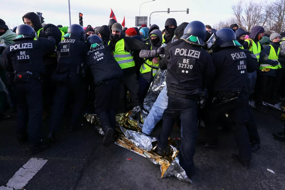 Police officers stand in front of protesters, as the protesters block a road during a demonstration, near the venue for the far-right Alternative for Germany (AfD) party congress in Riesa, Germany, January 11, 2025. REUTERS/Thilo Schmuelgen