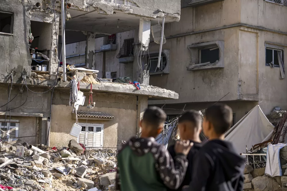 FILE - Palestinians look at a damaged residential building following an overnight Israeli strike in Deir al-Balah, Gaza Strip, Wednesday, Jan. 8, 2025. (AP Photo/Abdel Kareem Hana, File)