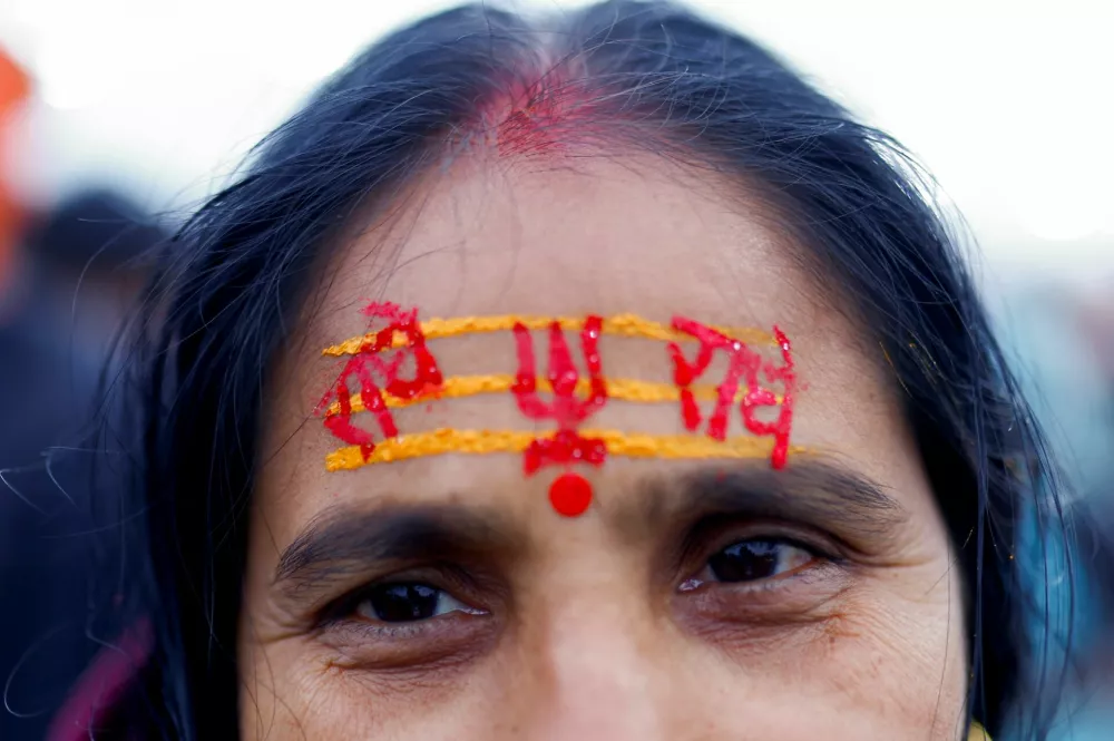 A woman devotee attends the "Maha Kumbh Mela", or the Great Pitcher Festival on the day devotees take a holy dip at Sangam, the confluence of the Ganges, Yamuna and mythical, invisible Saraswati rivers, in Prayagraj, India, January 13, 2025. REUTERS/Anushree Fadnavis