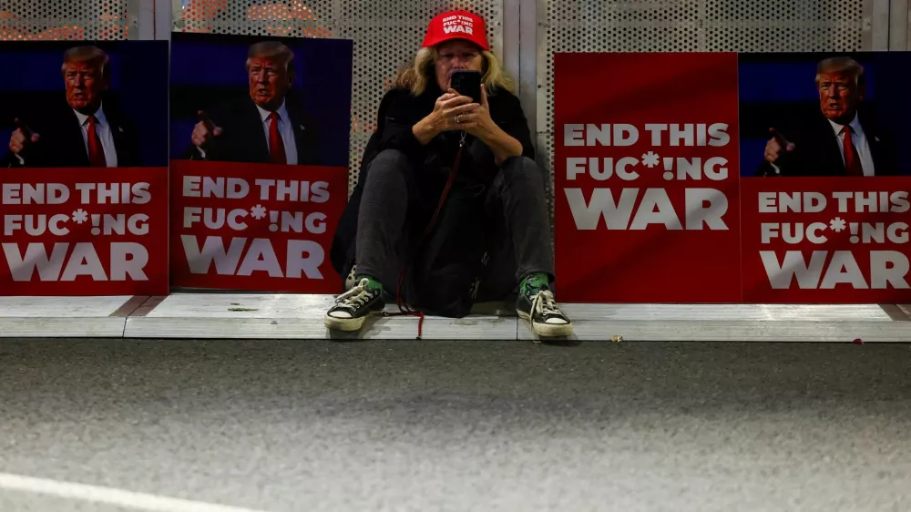 FILE PHOTO: A woman sits between placards with pictures of U.S. President-elect Donald Trump, on the day of a protest against the government and to show support for the hostages who were kidnapped during the deadly October 7, 2023 attack, amid the conflict in Gaza between Israel and Hamas, in Tel Aviv, Israel January 11, 2025. REUTERS/Kai Pfaffenbach/File Photo