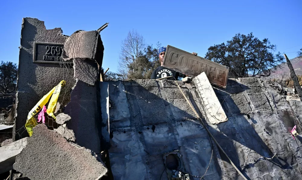 A man holds a sign picked up amid the rubble of what was once the family business, the Little Hen Coffee Shop, which burned in the Eaton Fire, in Altadena, California, on January 23, 2025. The coffee shop was run by his grandmother who was ready to hand it over to the younger generation, before it was burnt down by the Eaton Fire sixteen days ago. California Governor Gavin Newsom today signed legislation directing $2.5 billion in relief to support response and recovery efforts for Los Angeles.,Image: 957070458, License: Rights-managed, Restrictions:, Model Release: no / Foto: Profimedia.si