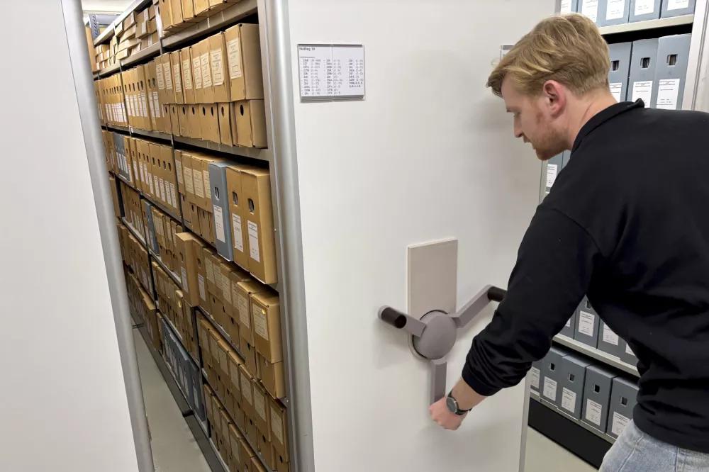 An archivist opens a sliding file cabinet where documents, some regarding WWII collaboration, are stored at the NIOD Institute for War, Holocaust and Genocide Studies in Amsterdam, Netherlands, Friday, Jan. 10, 2025. (AP Photo/Aleks Furtula)