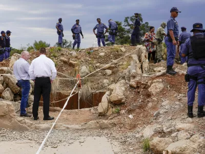 FILE - Police officers and private security personnel stand by the opening of a reformed gold mineshaft where illegal miners are trapped in Stilfontein, South Africa, Friday, Nov.15, 2024. (AP Photo/Denis Farrell, File)