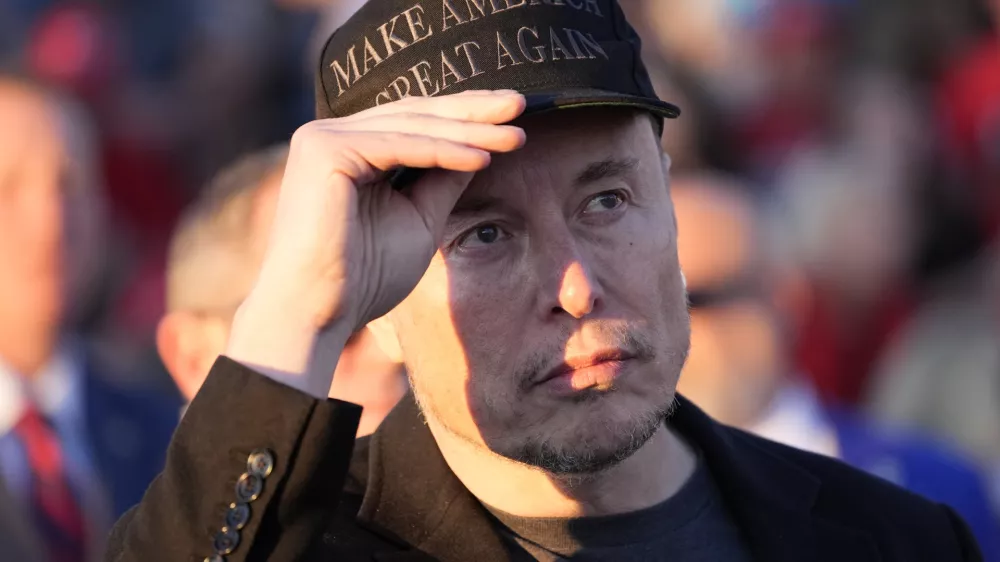 FILE - Tesla and SpaceX CEO Elon Musk listens as Republican presidential nominee former President Donald Trump speaks at a campaign event at the Butler Farm Show, on Oct. 5, 2024, in Butler, Pa. (AP Photo/Alex Brandon, File)