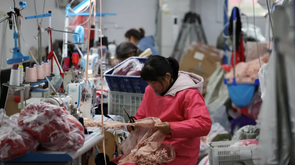 FILE PHOTO: Employees work on the production line at the Midnight Charm Garment lingerie factory in Guanyun county of Lianyungang, Jiangsu province, China November 25, 2024. REUTERS/Florence Lo/File Photo