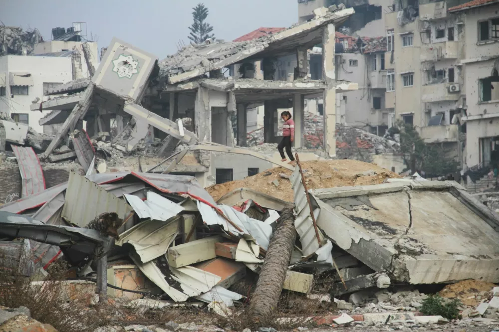 A Palestinian girl walks amid the rubble of buildings destroyed in previous Israeli strikes, ahead of a ceasefire set to take effect on Sunday, in Gaza City January 16, 2025. REUTERS/Mahmoud Issa