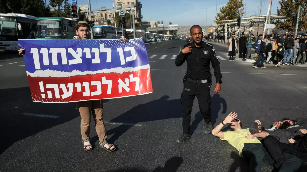 A man holds a banner that reads ''Yes to victory, no to surrender'', as people protest a ceasefire deal that they think may weaken Israel's future security, in Jerusalem, January 16, 2025. REUTERS/Ronen Zvulun