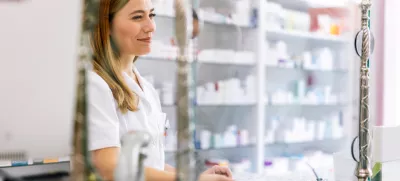 Woman pharmacist consulting customer at counter for prescription drugs or medicine at the pharmacy. Female doctor giving patient medical antibiotics at the pharmacy / Foto: Jovanmandic