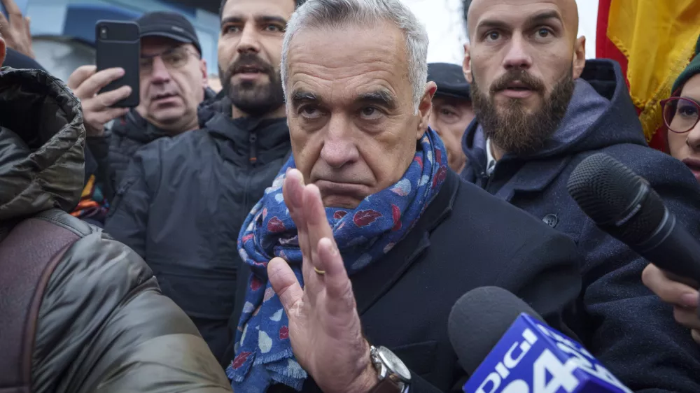 Calin Georgescu, center, an independent candidate for president who won the first round of presidential elections, makes his way, surrounded by media, to a closed voting station after Romania's Constitutional Court annulled the first round of presidential elections, in Mogosoaia, Romania, Sunday, Dec. 8, 2024. (AP Photo/Vadim Ghirda)