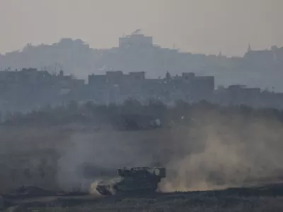 An Israeli army APC moves in the Gaza Strip as seen from southern Israel on Thursday, Jan. 16, 2025. (AP Photo/Ariel Schalit)