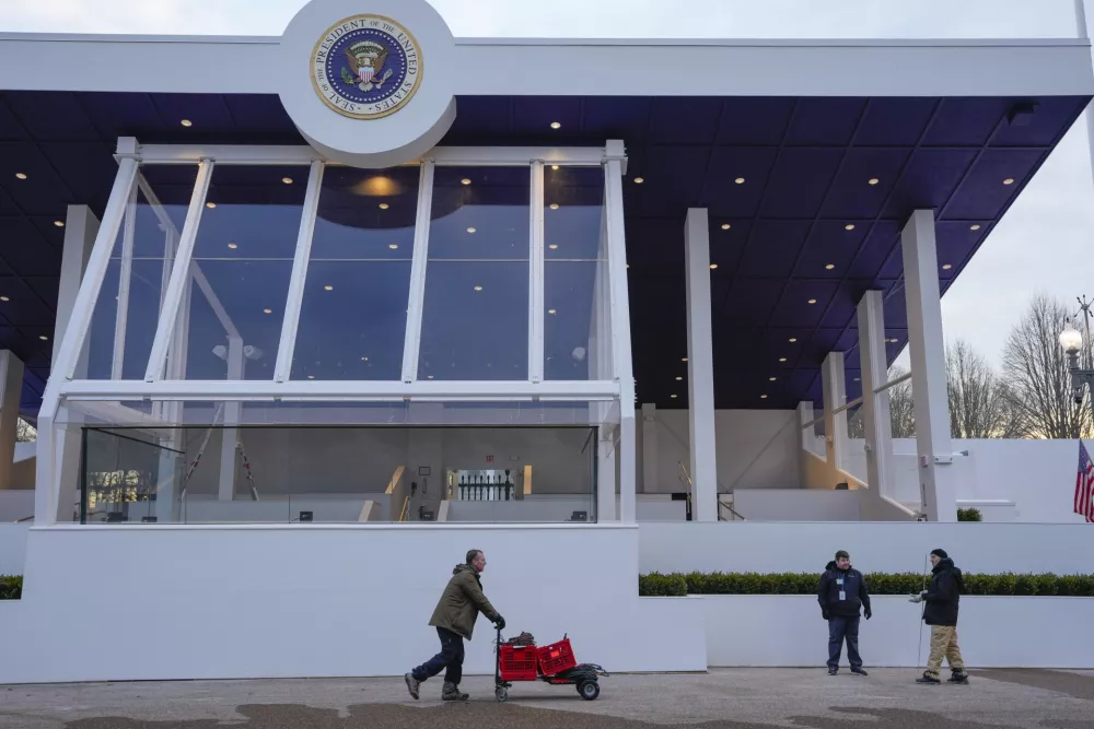 Workers continue with the finishing touches on the presidential reviewing stand on Pennsylvania outside the White House Thursday, Jan. 16, 2025, in Washington, ahead of President-elect Donald Trump's inauguration. (Jon Elswick via AP)