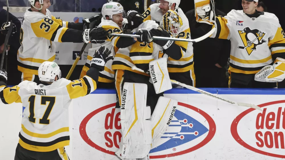 Pittsburgh Penguins goaltender Alex Nedeljkovic, center, celebrates with teammates after scoring during the third period of an NHL hockey game against the Buffalo Sabres, Friday, Jan. 17, 2025, in Buffalo, N.Y. (AP Photo/Jeffrey T. Barnes)