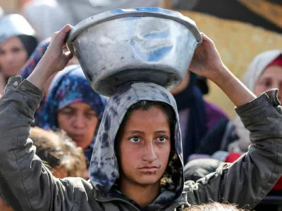 Palestinians gather to receive food cooked by a charity kitchen, before a ceasefire between Hamas and Israel takes effect, in Khan Younis, in the southern Gaza Strip, January 17, 2025. REUTERS/Hatem Khaled   TPX IMAGES OF THE DAY