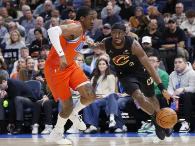 Cleveland Cavaliers guard Caris LeVert, right, drives against Oklahoma City Thunder forward Jalen Williams, left, during the second half of an NBA basketball game Thursday, Jan. 16, 2025, in Oklahoma City. (AP Photo/Nate Billings)