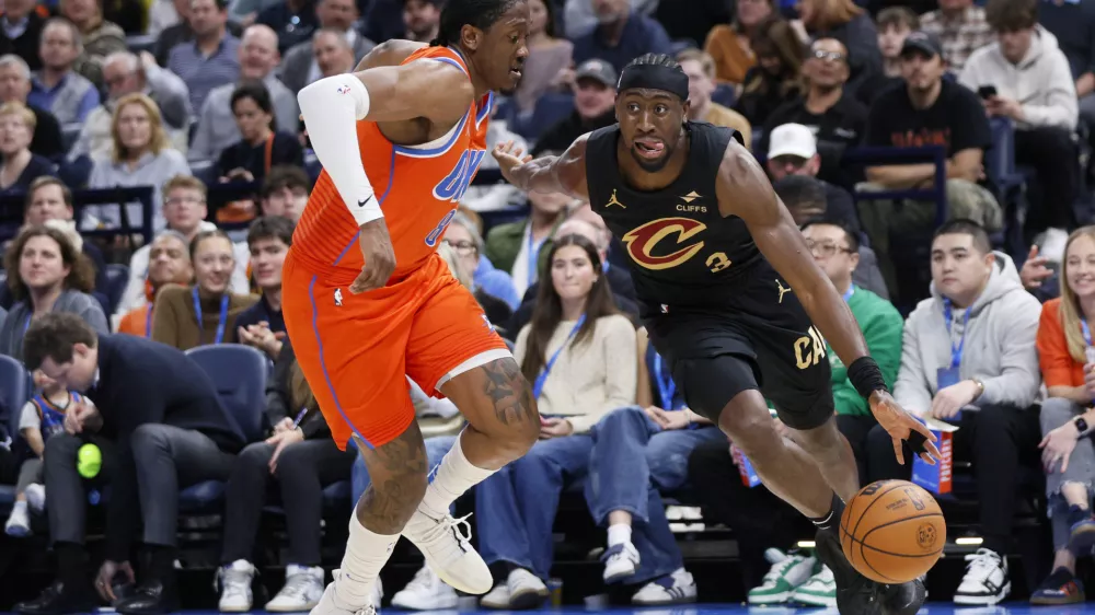 Cleveland Cavaliers guard Caris LeVert, right, drives against Oklahoma City Thunder forward Jalen Williams, left, during the second half of an NBA basketball game Thursday, Jan. 16, 2025, in Oklahoma City. (AP Photo/Nate Billings)