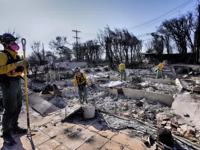 Lt. Matt Phillips, left, from Kitsap County firefighting strike team from Bainbridge Island, Wash., directs his crew while checking homes for structural issues in the aftermath of the Palisades Fire in the Pacific Palisades neighborhood of Los Angeles on Friday. Jan. 17, 2025. (AP Photo/Richard Vogel)