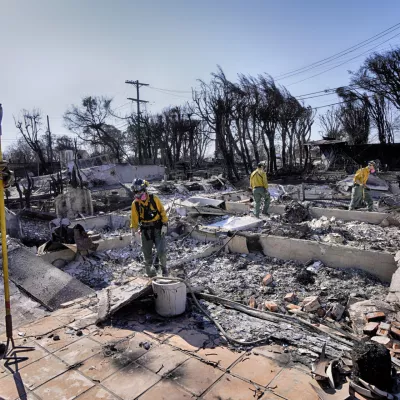 Lt. Matt Phillips, left, from Kitsap County firefighting strike team from Bainbridge Island, Wash., directs his crew while checking homes for structural issues in the aftermath of the Palisades Fire in the Pacific Palisades neighborhood of Los Angeles on Friday. Jan. 17, 2025. (AP Photo/Richard Vogel)