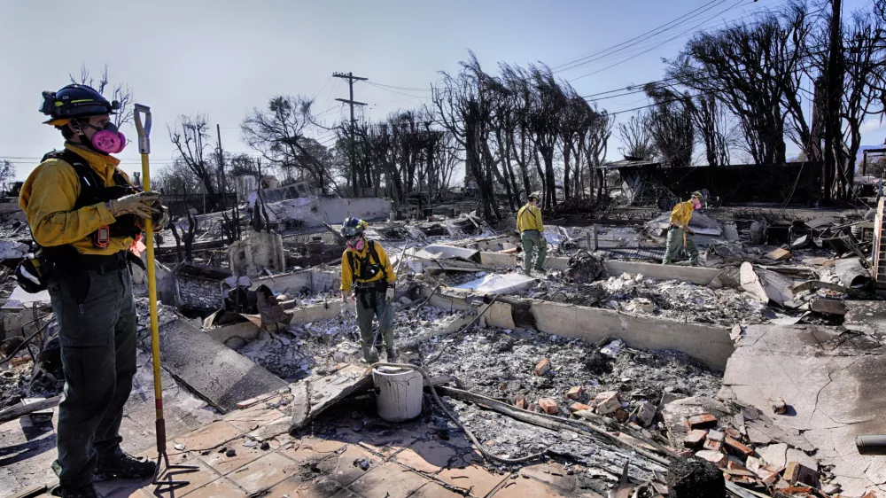 Lt. Matt Phillips, left, from Kitsap County firefighting strike team from Bainbridge Island, Wash., directs his crew while checking homes for structural issues in the aftermath of the Palisades Fire in the Pacific Palisades neighborhood of Los Angeles on Friday. Jan. 17, 2025. (AP Photo/Richard Vogel)