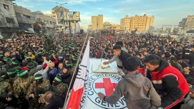 Palestinian Hamas militants and people gather around a Red Cross vehicle before the release of hostages kidnapped during the October 7, 2023, attack on Israel by Hamas, as part of a ceasefire and a hostages-prisoners swap deal between Hamas and Israel, in Gaza City, January 19, 2025. REUTERS/Dawoud Abu Alkas  TPX IMAGES OF THE DAY