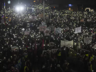 People protest in front of the state-run TV headquarters, a day after a young student protester was hit by a car and seriously wounded in Belgrade, Serbia, Friday, Jan. 17, 2025. (AP Photo/Darko Vojinovic)