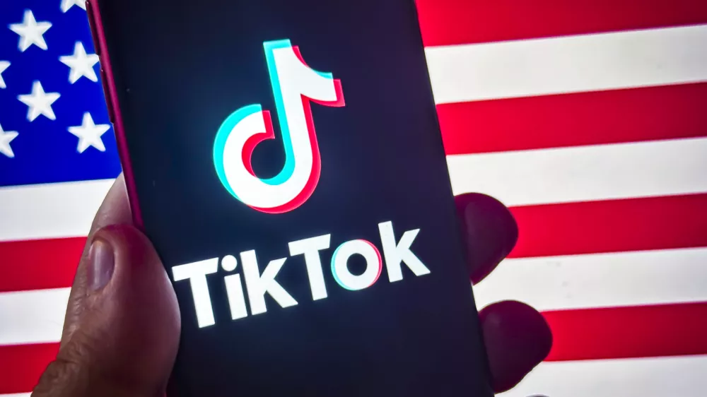 18 January 2025, US, ---: Social Media App TikTok logo Pictured on smart phone before the US flag. A law banning TikTok in the US unless it is sold by its Chinese parent company, ByteDance, is set to come into force on 19 January. Photo: Taidgh Barron/ZUMA Press Wire/dpa