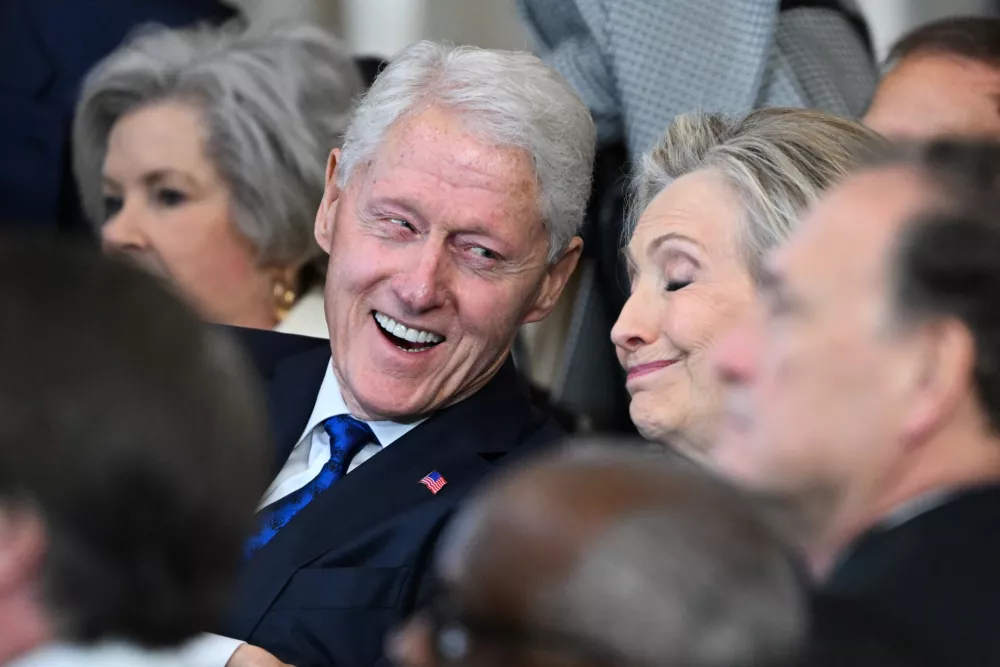 (L-R) Former US President Bill Clinton and former Secretary of State Hillary Clinton listen as President Donald Trump speaks after being sworn in as the 47th President in the US Capitol Rotunda in Washington, DC, on January 20, 2025.  SAUL LOEB/Pool via REUTERS