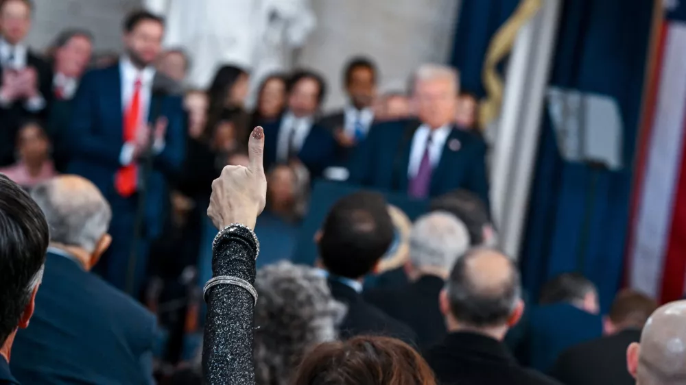 A supporter raises their hand while U.S. President Donald Trump speaks during the inauguration of Donald Trump as the 47th president of the United States takes place inside the Capitol Rotunda of the U.S. Capitol building in Washington, D.C., Monday, January 20, 2025. It is the 60th U.S. presidential inauguration and the second non-consecutive inauguration of Trump as U.S. president. Kenny Holston/Pool via REUTERS