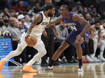 Dallas Mavericks guard Kyrie Irving (11) drives to the basket against Charlotte Hornets forward Moussa Diabate (14) during the first half of an NBA basketball game on Monday, Jan. 20, 2025, in Charlotte, N.C. (AP Photo/Jim Dedmon)