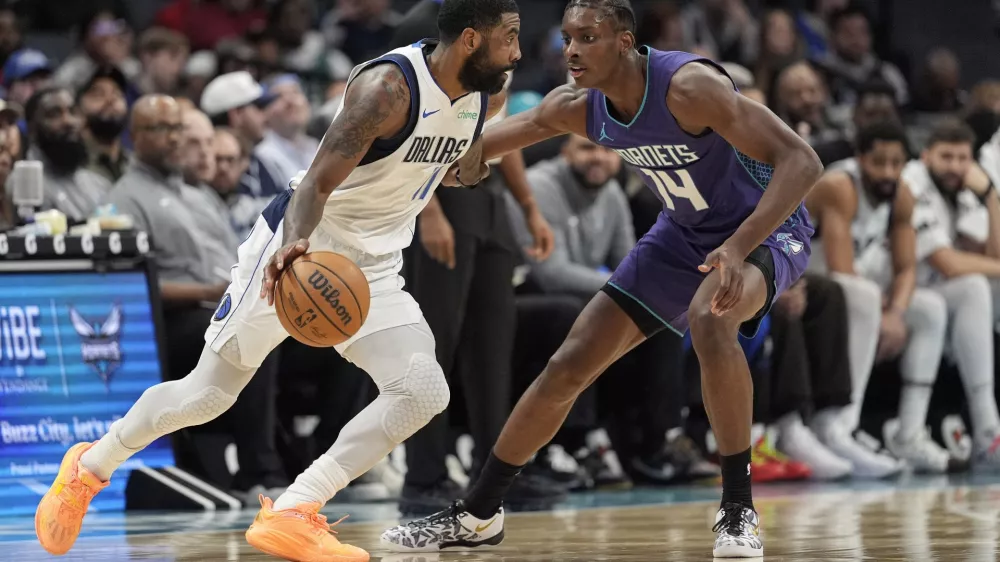 Dallas Mavericks guard Kyrie Irving (11) drives to the basket against Charlotte Hornets forward Moussa Diabate (14) during the first half of an NBA basketball game on Monday, Jan. 20, 2025, in Charlotte, N.C. (AP Photo/Jim Dedmon)