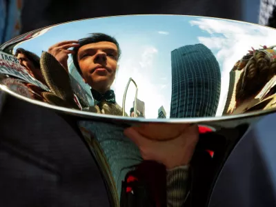 ﻿A cast member looks at his reflection in a trombone as he fixes his hair while the cast of Broadway show The Music Man pose for photos across the street from the Winter Garden in the Manhattan borough of New York City, New York, U.S., February 8, 2022. REUTERS/Carlo Allegri   TPX IMAGES OF THE DAY