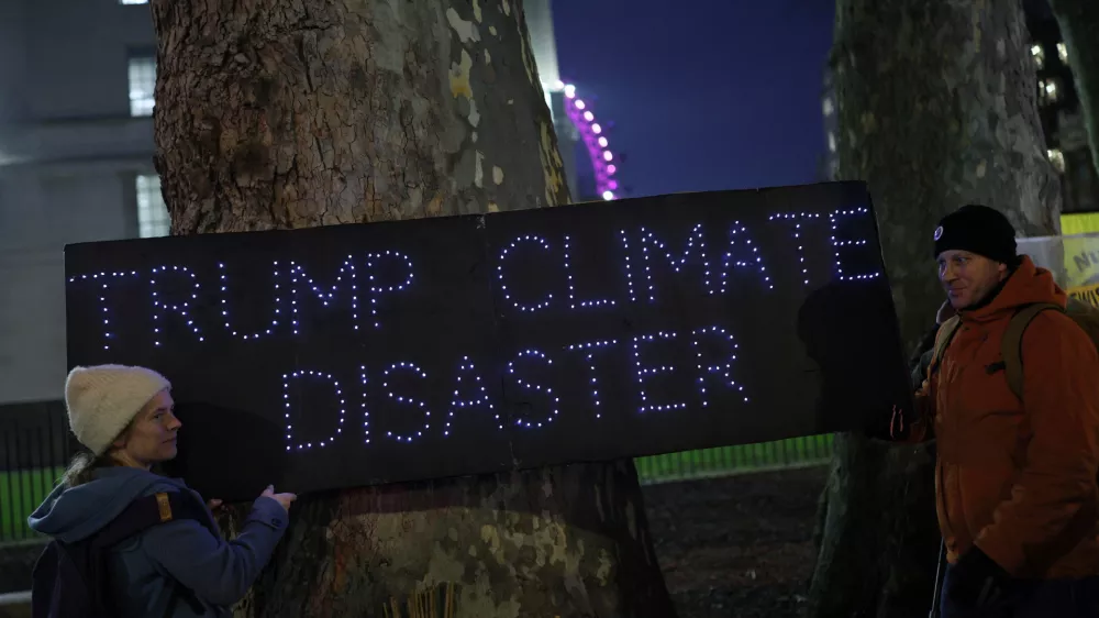 Demonstrators hold a placard that reads "Trump Climate Disaster" during a protest against the inauguration of Donald Trump as U.S. president, in London, Britain, January 20, 2025. REUTERS/Isabel Infantes