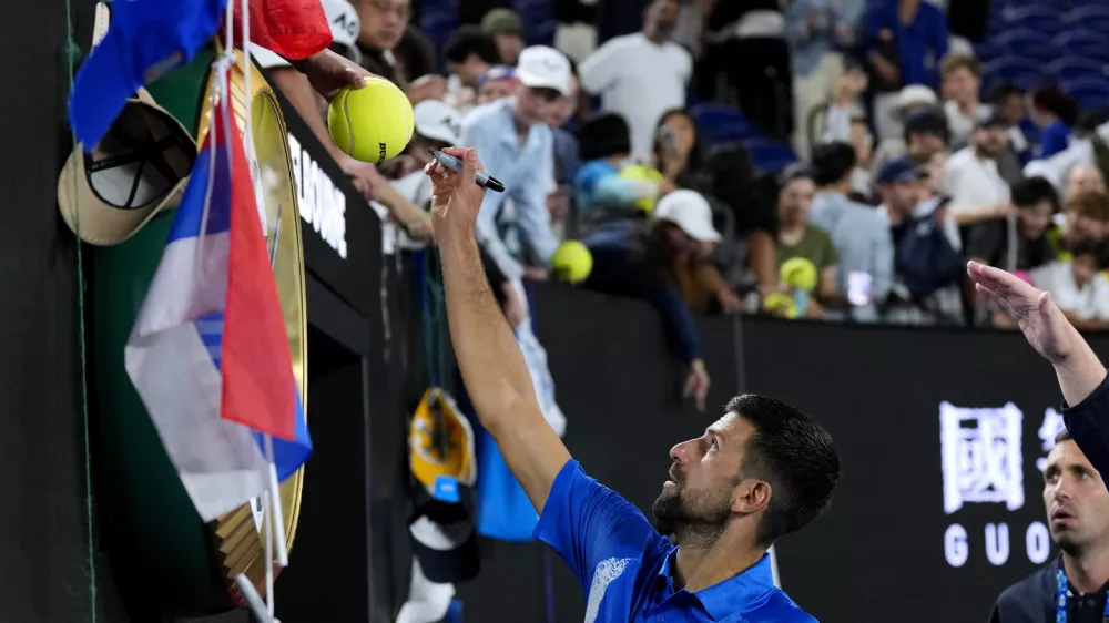 Novak Djokovic of Serbia signs autographs after his quarterfinal match against Carlos Alcaraz of Spain at the Australian Open tennis championship in Melbourne, Australia, Wednesday, Jan. 22, 2025. (AP Photo/Vincent Thian)