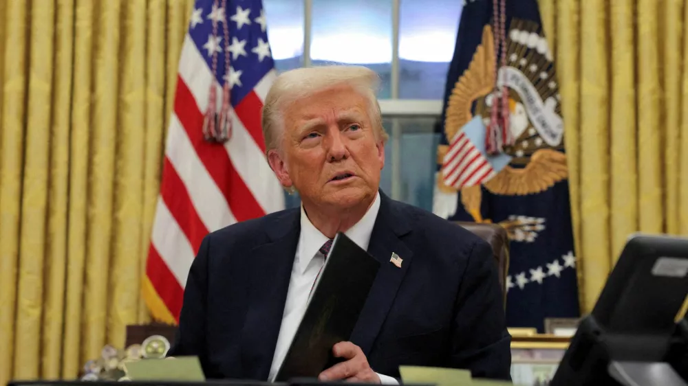 FILE PHOTO: U.S. President Donald Trump signs documents as he issues executive orders and pardons for January 6 defendants in the Oval Office at the White House on Inauguration Day in Washington, U.S., January 20, 2025. REUTERS/Carlos Barria//File Photo