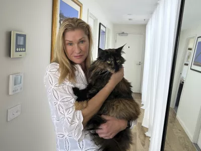 Margo Neas holds her cat Mittens at her home in Melbourne, Australia Wednesday, Jan. 22, 2025. (AP Photo/Rod McGuirk)