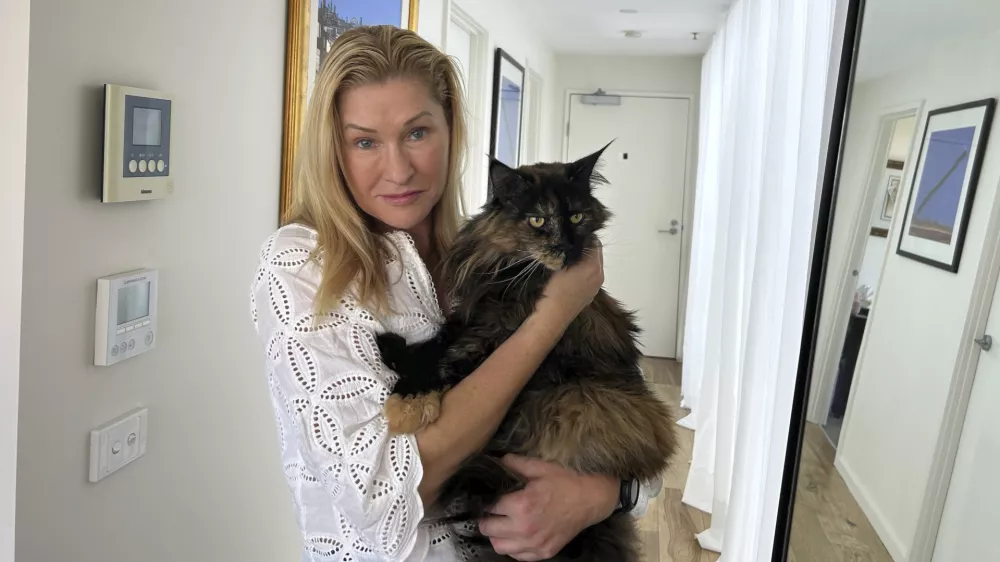 Margo Neas holds her cat Mittens at her home in Melbourne, Australia Wednesday, Jan. 22, 2025. (AP Photo/Rod McGuirk)