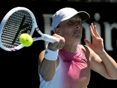 Iga Swiatek of Poland plays a forehand return to Emma Navarro of the U.S. during their quarterfinal match at the Australian Open tennis championship in Melbourne, Australia, Wednesday, Jan. 22, 2025. (AP Photo/Manish Swarup)