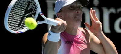 Iga Swiatek of Poland plays a forehand return to Emma Navarro of the U.S. during their quarterfinal match at the Australian Open tennis championship in Melbourne, Australia, Wednesday, Jan. 22, 2025. (AP Photo/Manish Swarup)