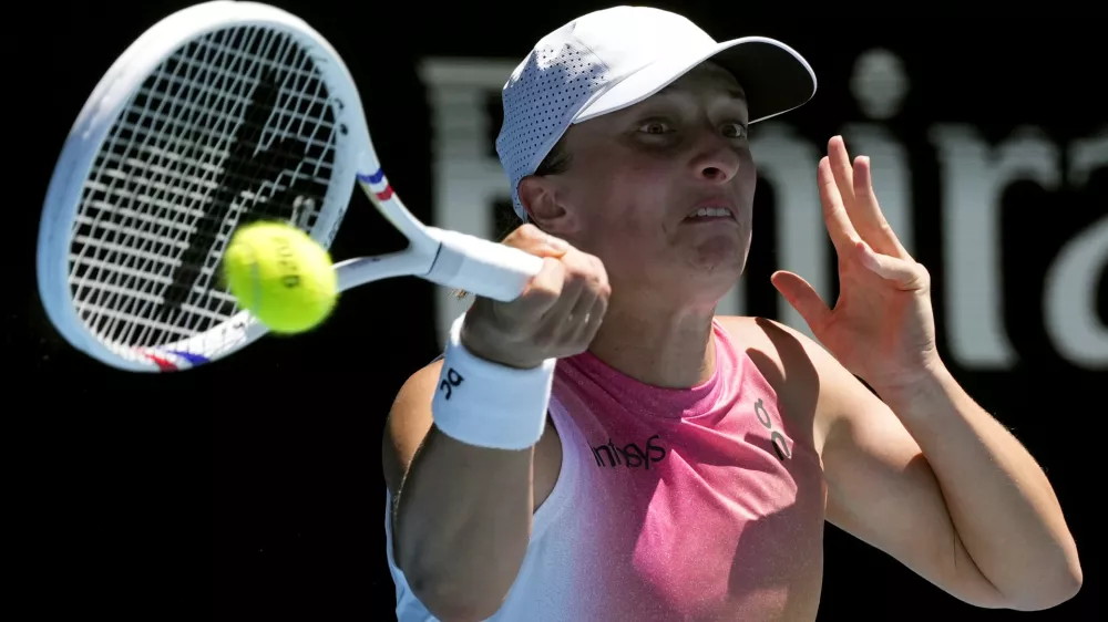 Iga Swiatek of Poland plays a forehand return to Emma Navarro of the U.S. during their quarterfinal match at the Australian Open tennis championship in Melbourne, Australia, Wednesday, Jan. 22, 2025. (AP Photo/Manish Swarup)