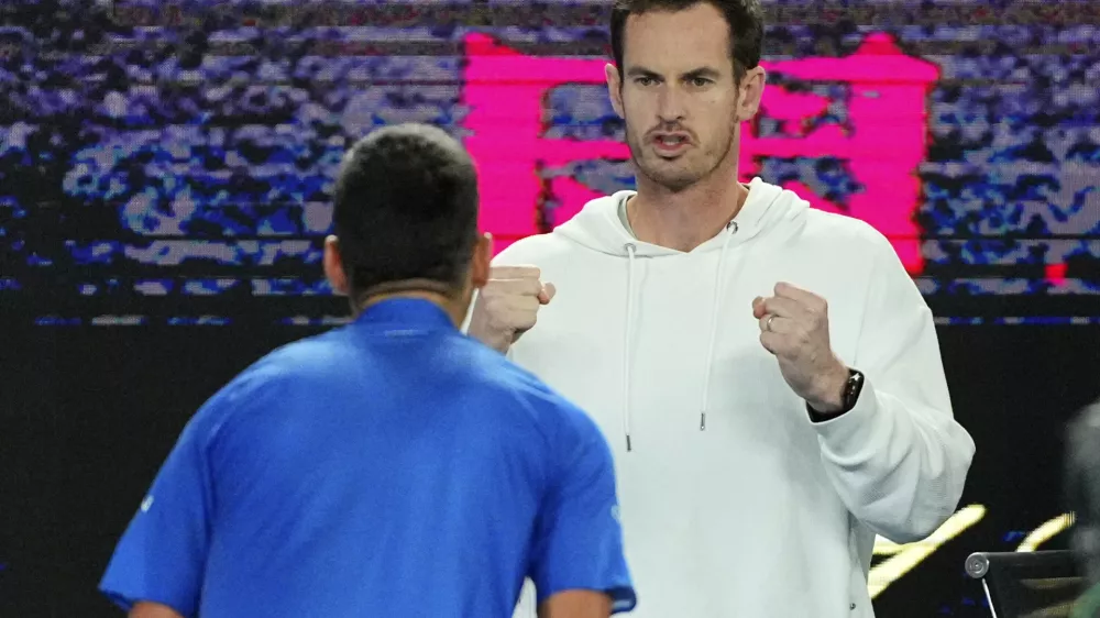 Andy Murray reacts with Novak Djokovic following his win over Carlos Alcaraz of Spain in their quarterfinal match at the Australian Open tennis championship in Melbourne, Australia, early Wednesday, Jan. 22, 2025. (AP Photo/Vincent Thian)