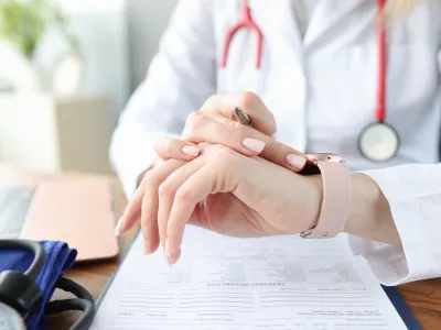 Doctor looks at clock at work table in medical office. Irregular working hours for health workers concept