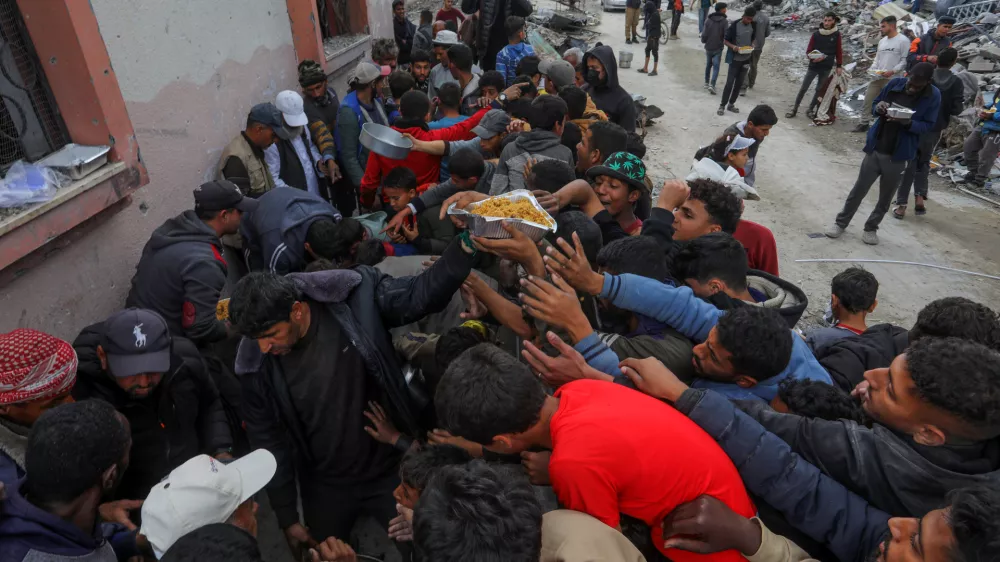 24 January 2025, Palestinian Territories, Rafah: Palestinians gather in a crowded line to receive food aid distributed by charitable organizations in Rafah, days after the ceasefire agreement between Israel and Hamas entered into force. Photo: Abed Rahim Khatib/dpa