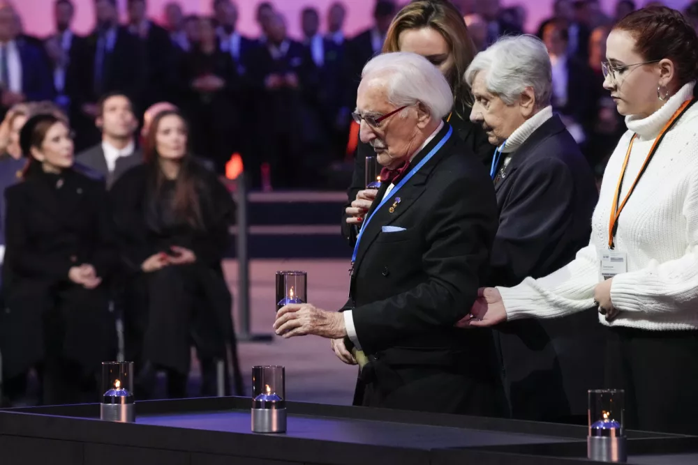 Former Auschwitz prisoner Leon Weintraub places a lilt candle at the Auschwitz-Birkenau former Nazi German concentration and extermination camp, during a ceremony marking the 80th anniversary of its liberation, in Oswiecim, Poland, Monday, Jan. 27. 2025. (AP Photo/Czarek Sokolowski)